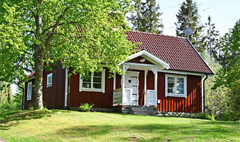 Torp i Småland med robåd ved sø