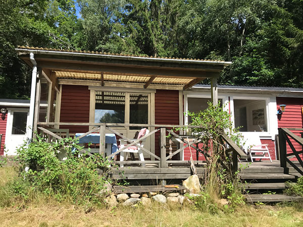 Sommerhus med udsigt over sø med bådebro og badestrand 