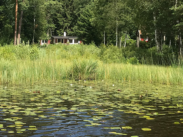 Sommerhus med udsigt over sø med bådebro og badestrand 