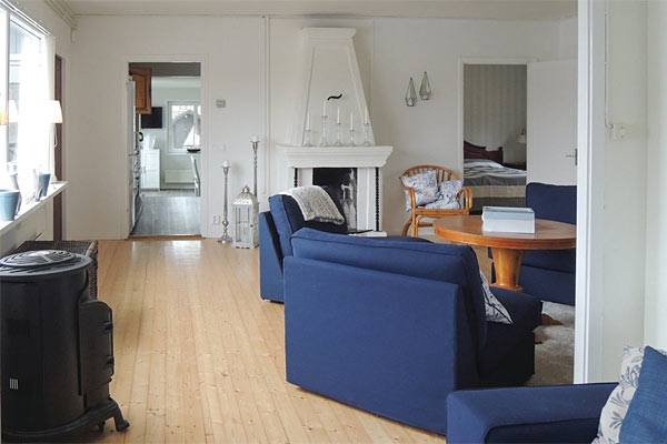 Sommerhusets opholdsstue med pejs Sommerhusets opholdsstue med pejs